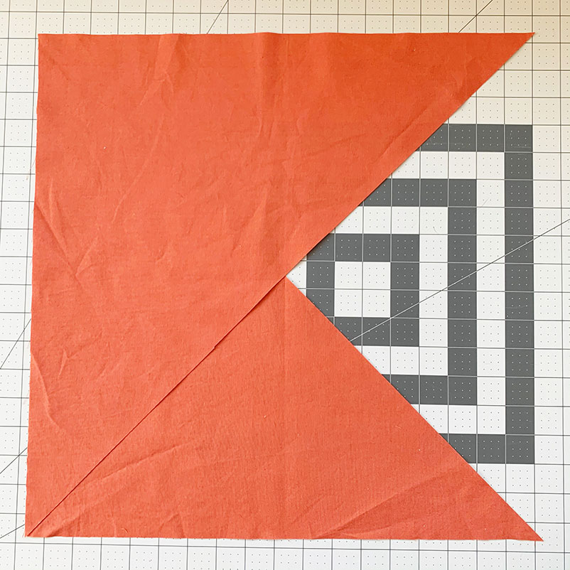 two triangles of fabric laid on top of one another with edge matching