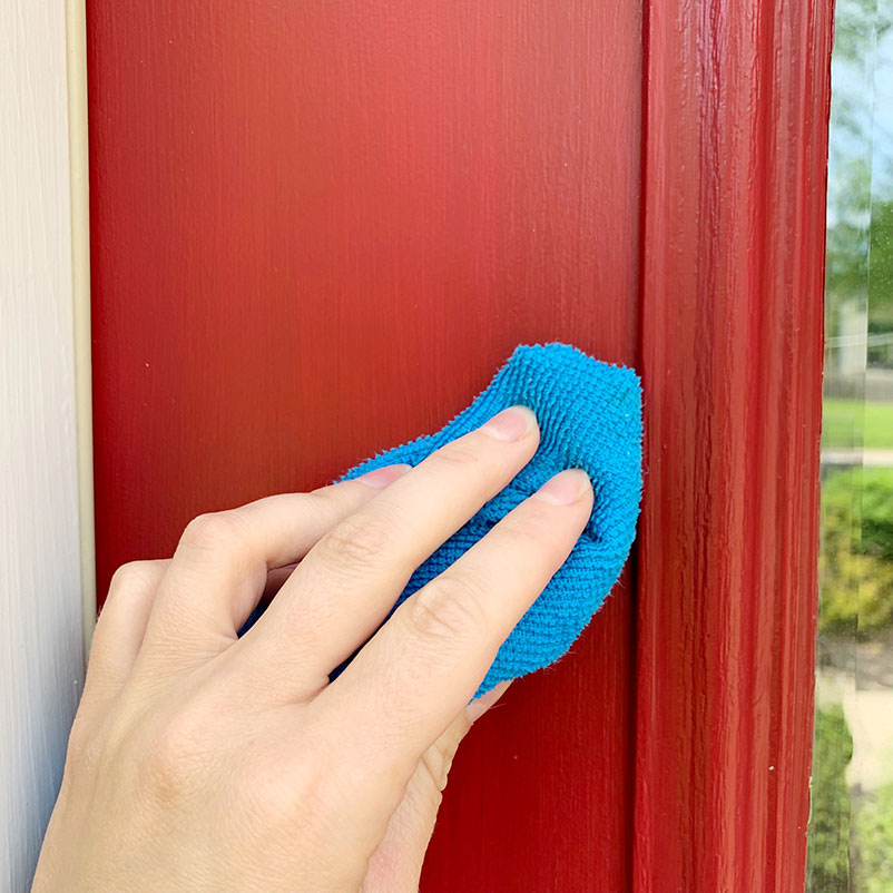 cleaning red door with blue rag.