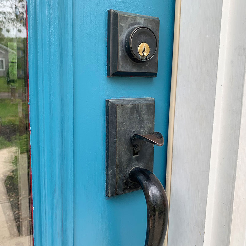 close up of lock and handle on door being painted around
