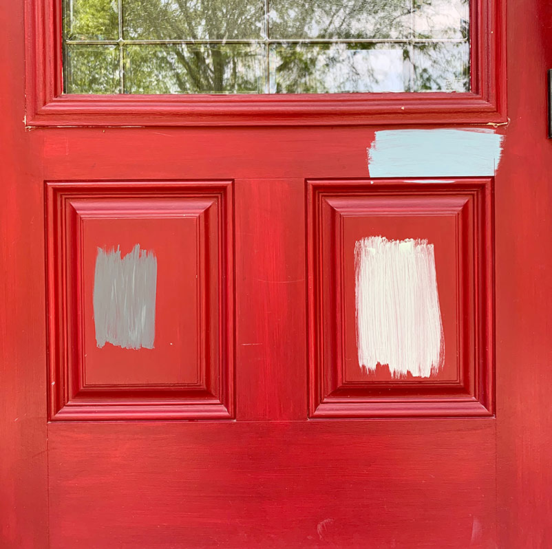 red door with three painted swatches, gray, light blue, and light green