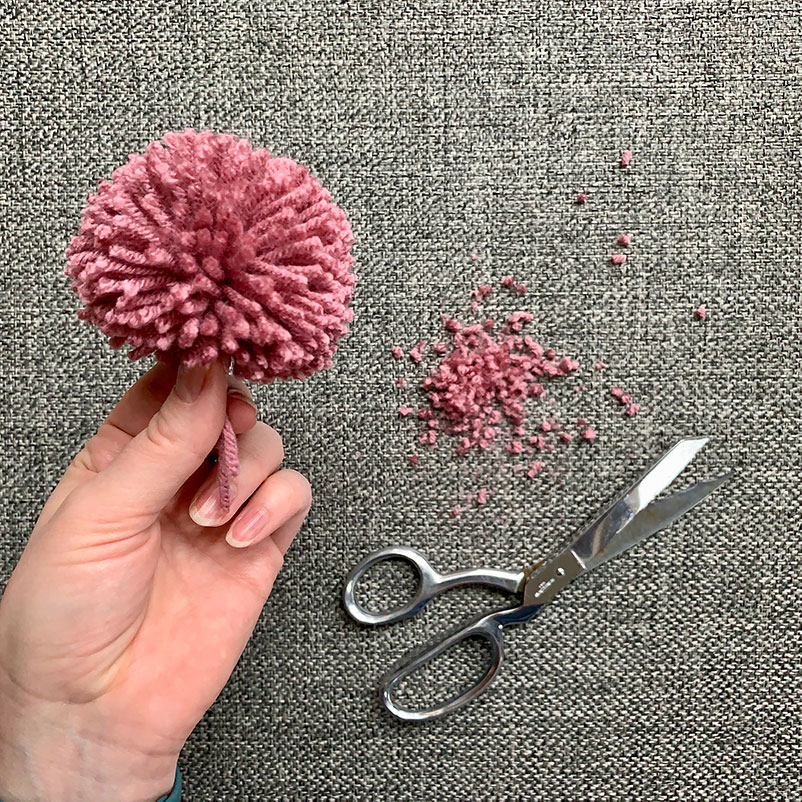 Pom Pom in hand after given a little cut with some scissors to make a more uniform shape