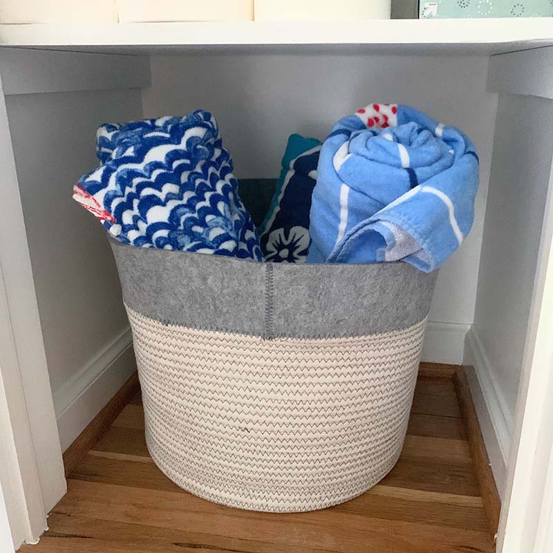 basket with pool towels on floor of closet