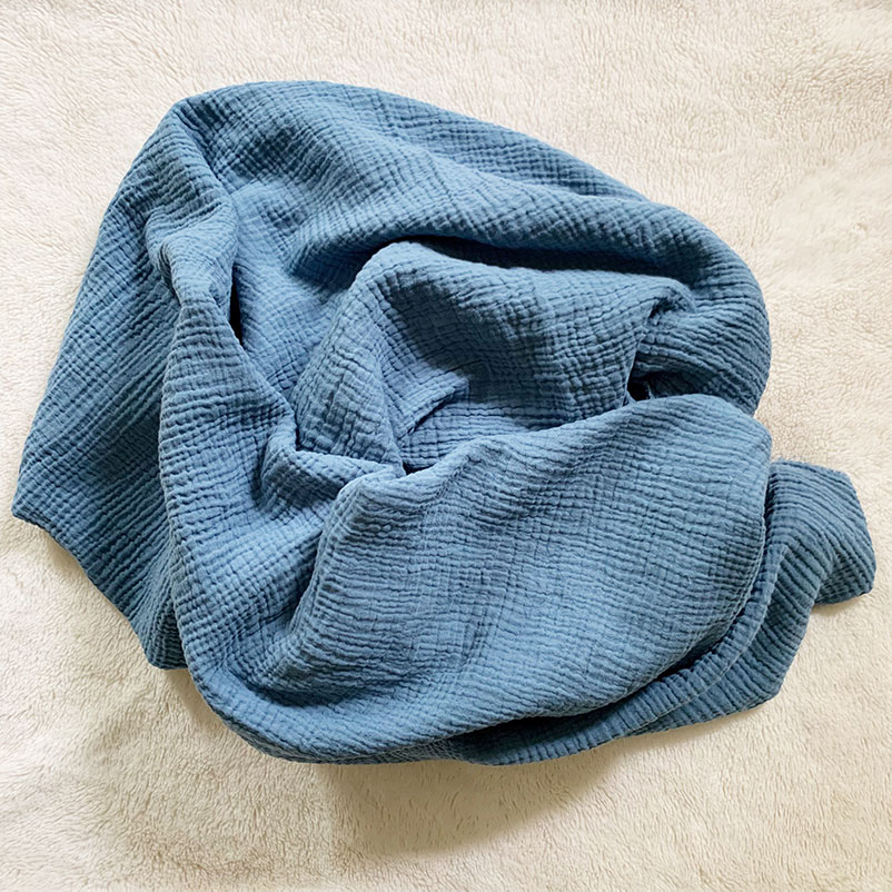 rumpled piece of double gauze fabric in denim color