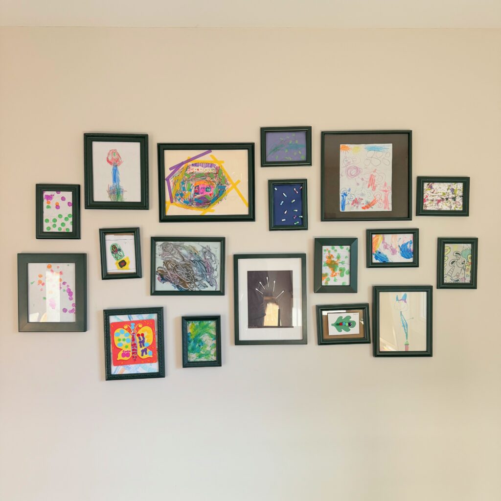 forward photo taken of gallery wall with kids art in the various frames