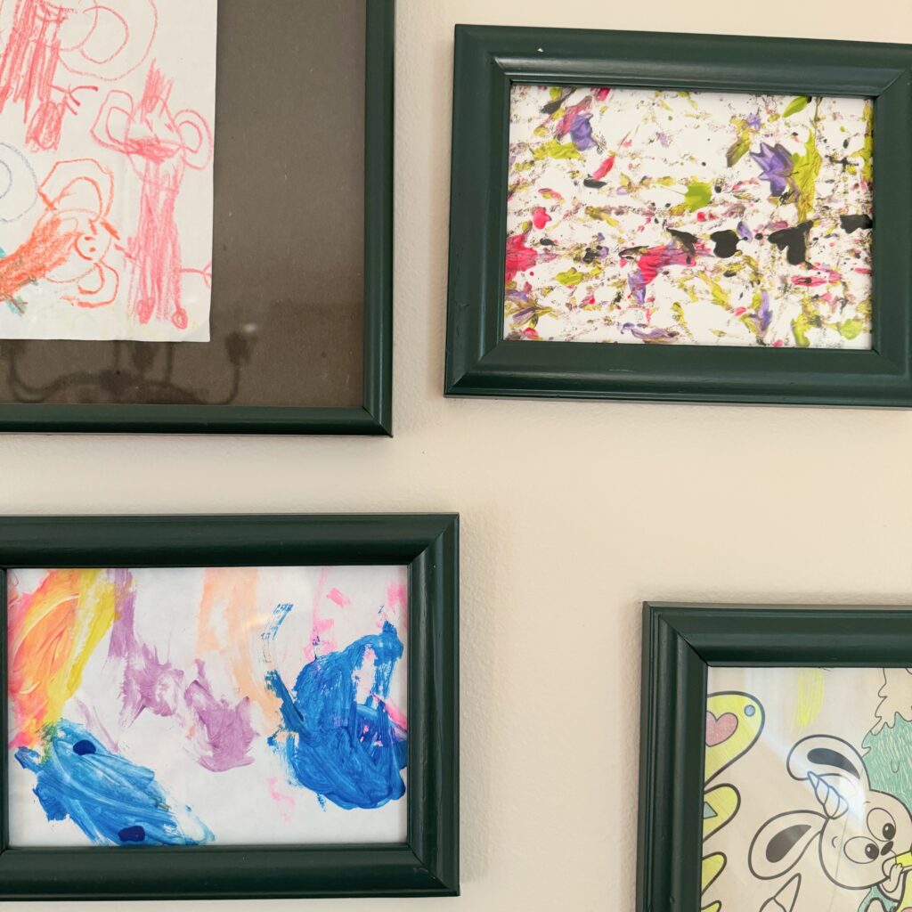 close up partial view of four frames in a gallery wall of kids art