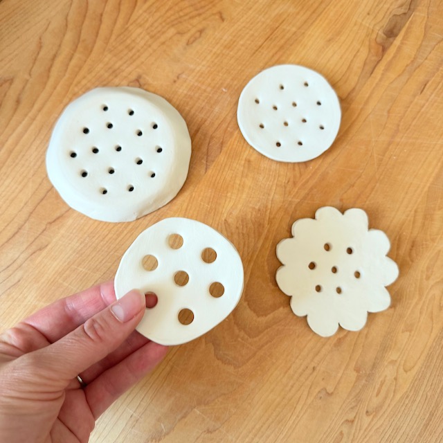 four air dry clay flower frogs on a wooden surface